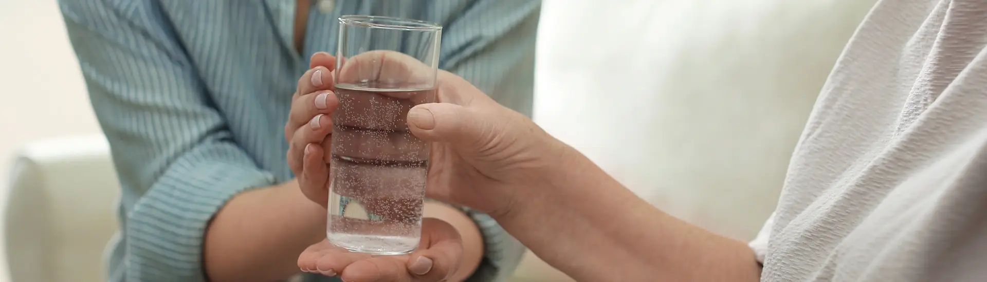 Woman grabbing glass of water