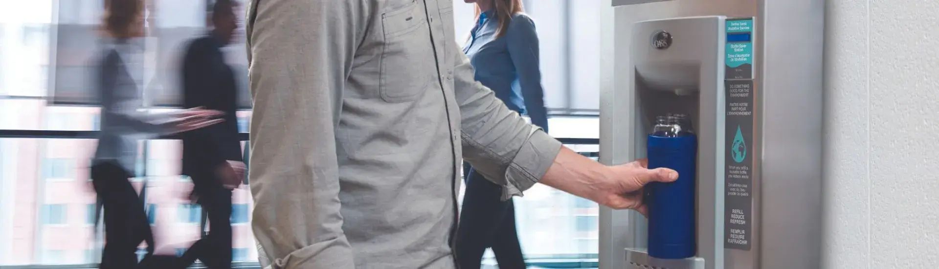 man filling reusable bottle at bottle filling station