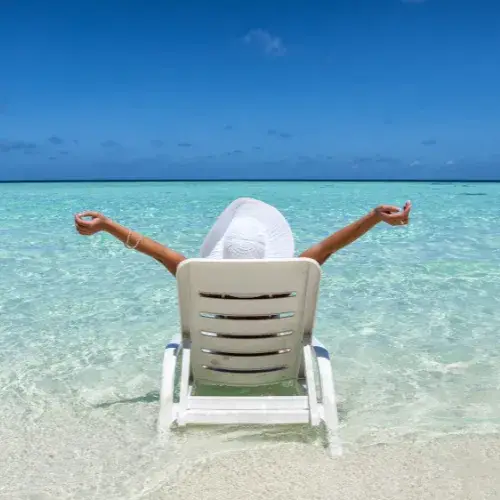 woman in sun lounger on beach in front of sea
