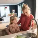 mother and daughter filling up a glass of water