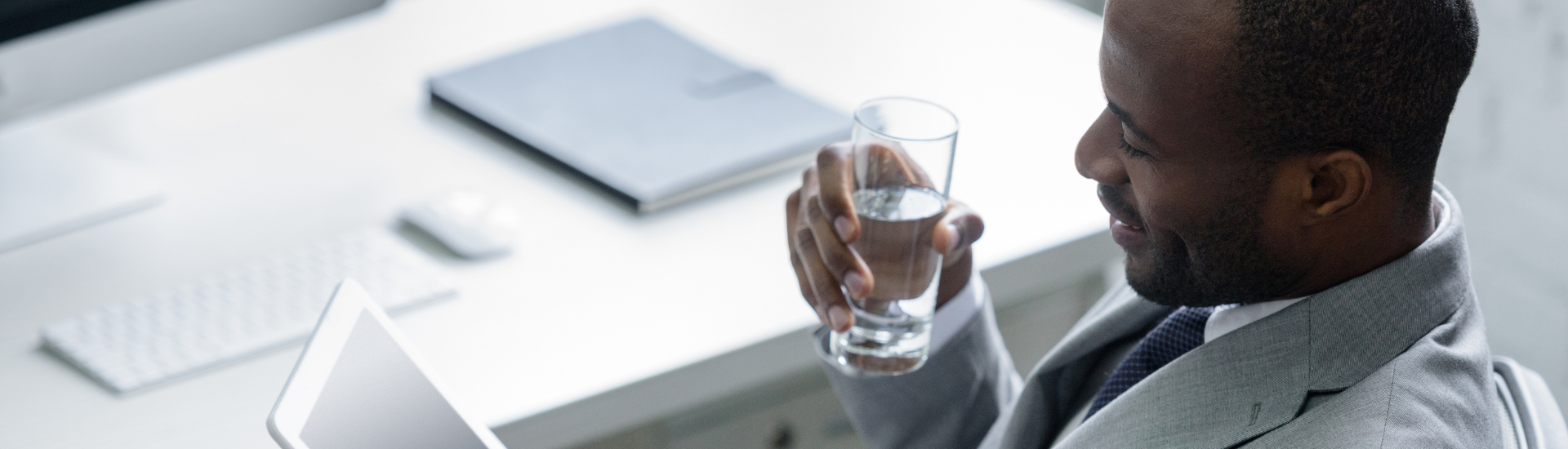 man in suit drinking glass of water