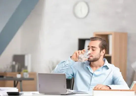 man drinking water at work